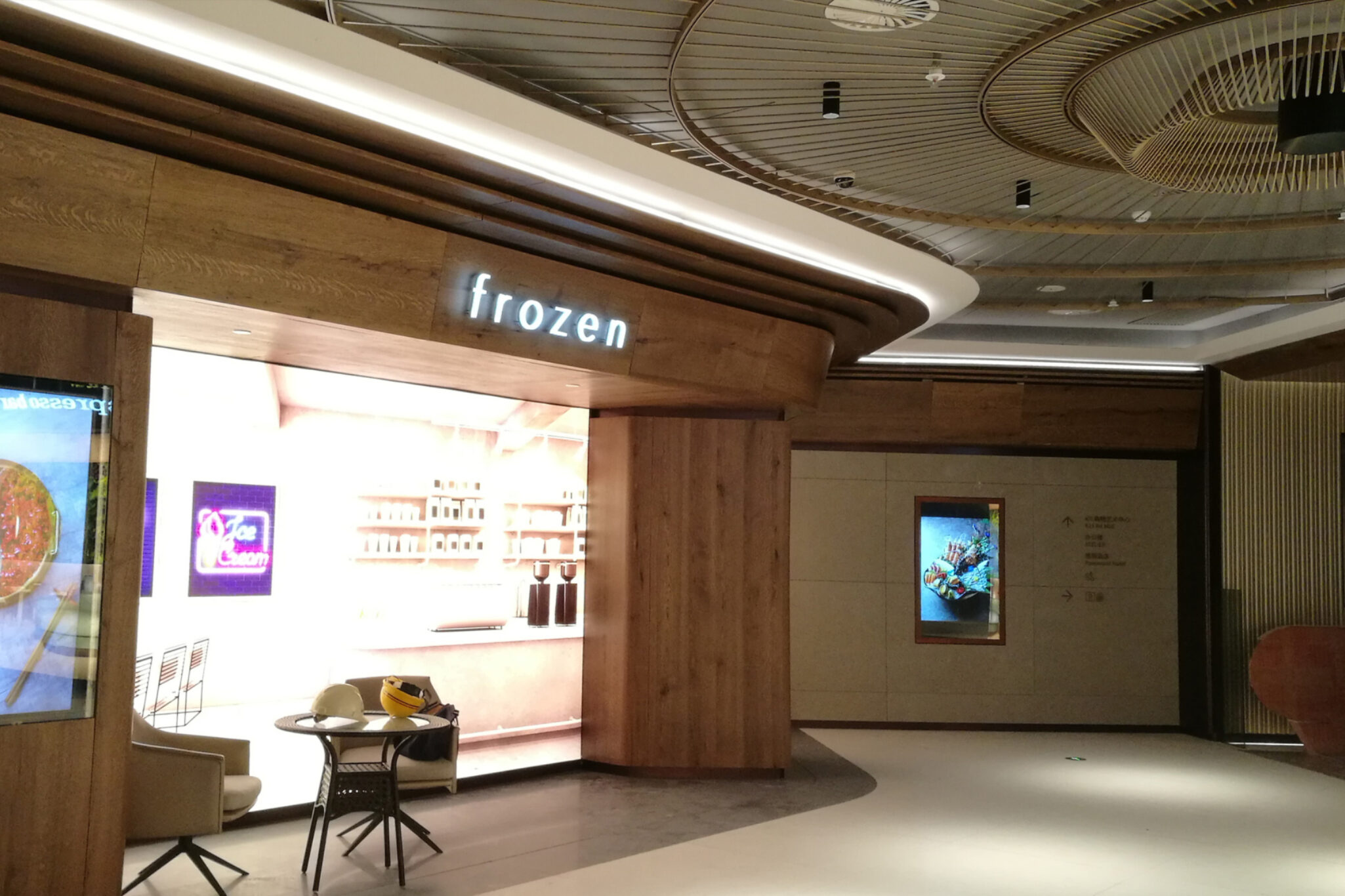 A side view of the FROZEN brand outlet inside a commercial plaza, a retail design project by the Studio X team