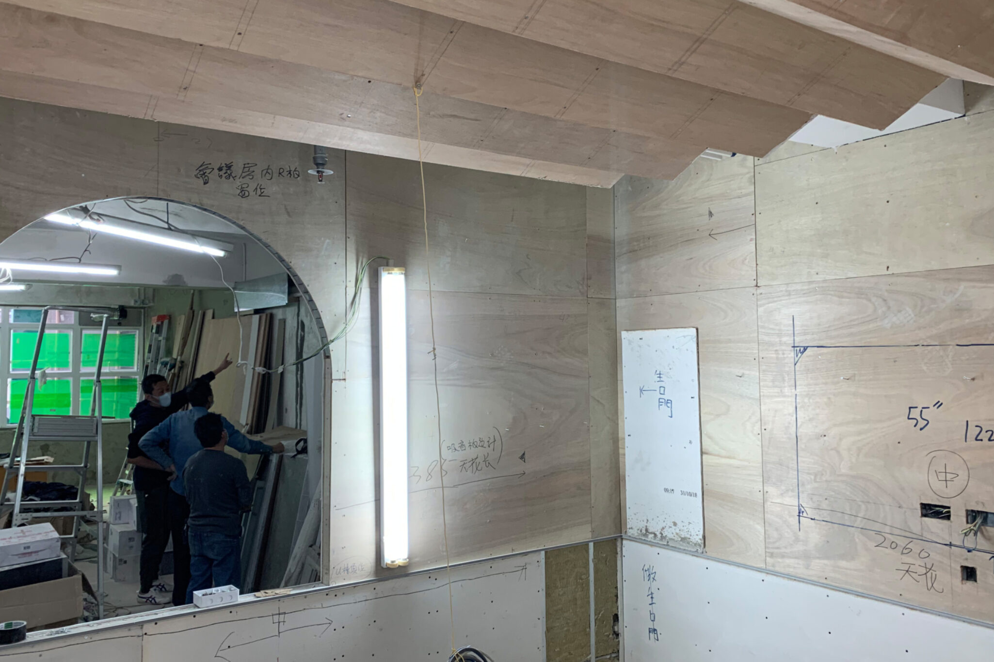A retail site under construction, with a team of people planning to finish the wooden work, a retail project of Studio X