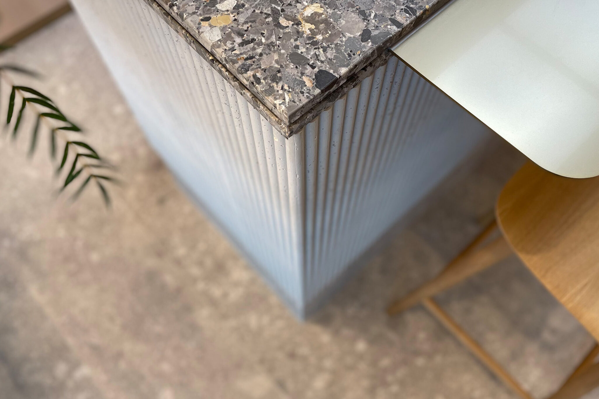 A close-up shot of a granite counter with a chair cropped aside, inside the Tea Chateau store, designed by Studio X