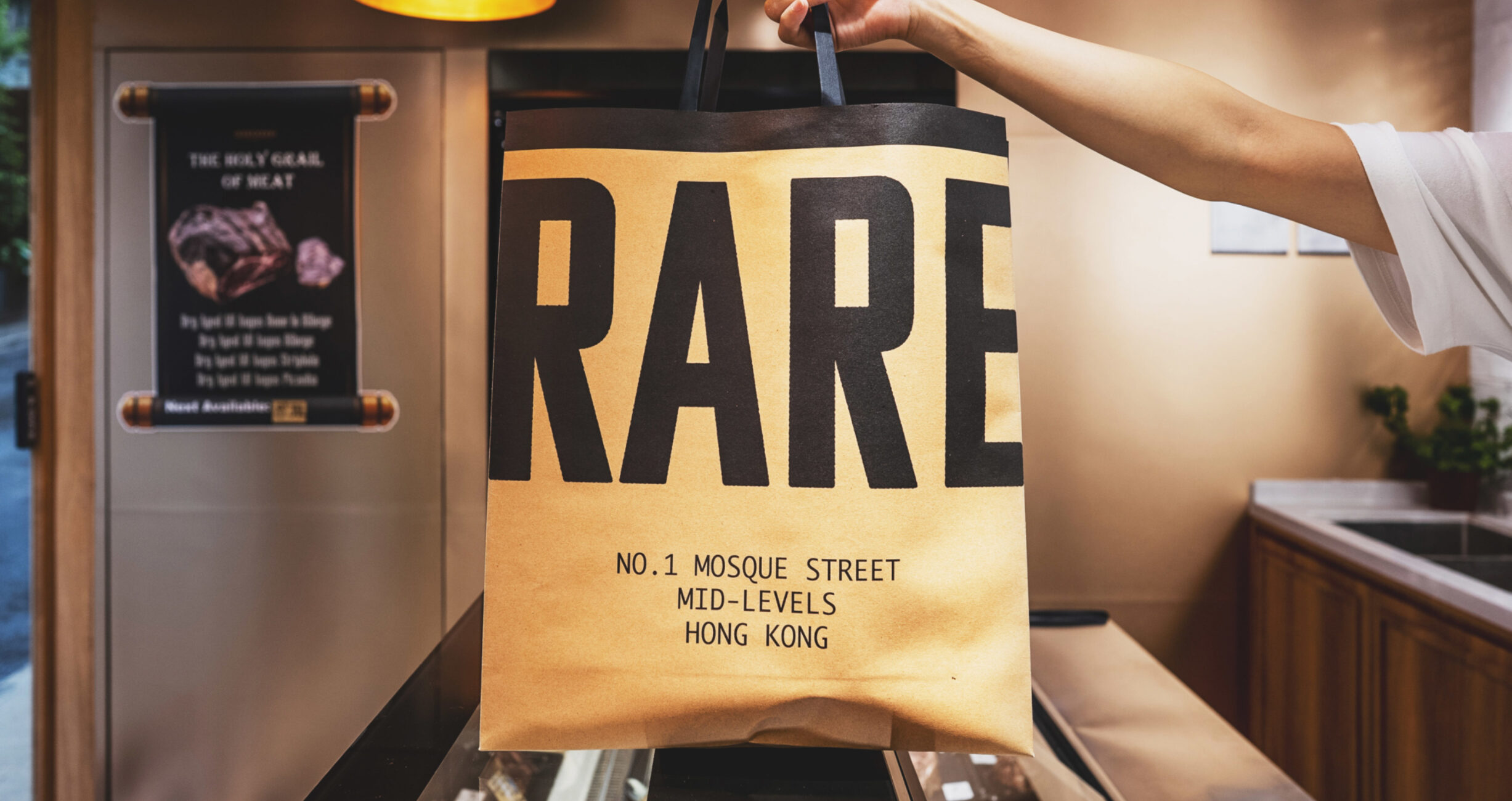 A food pack bag of the RARE brand held in someone's hand, featuring their tagline, a Studio X project