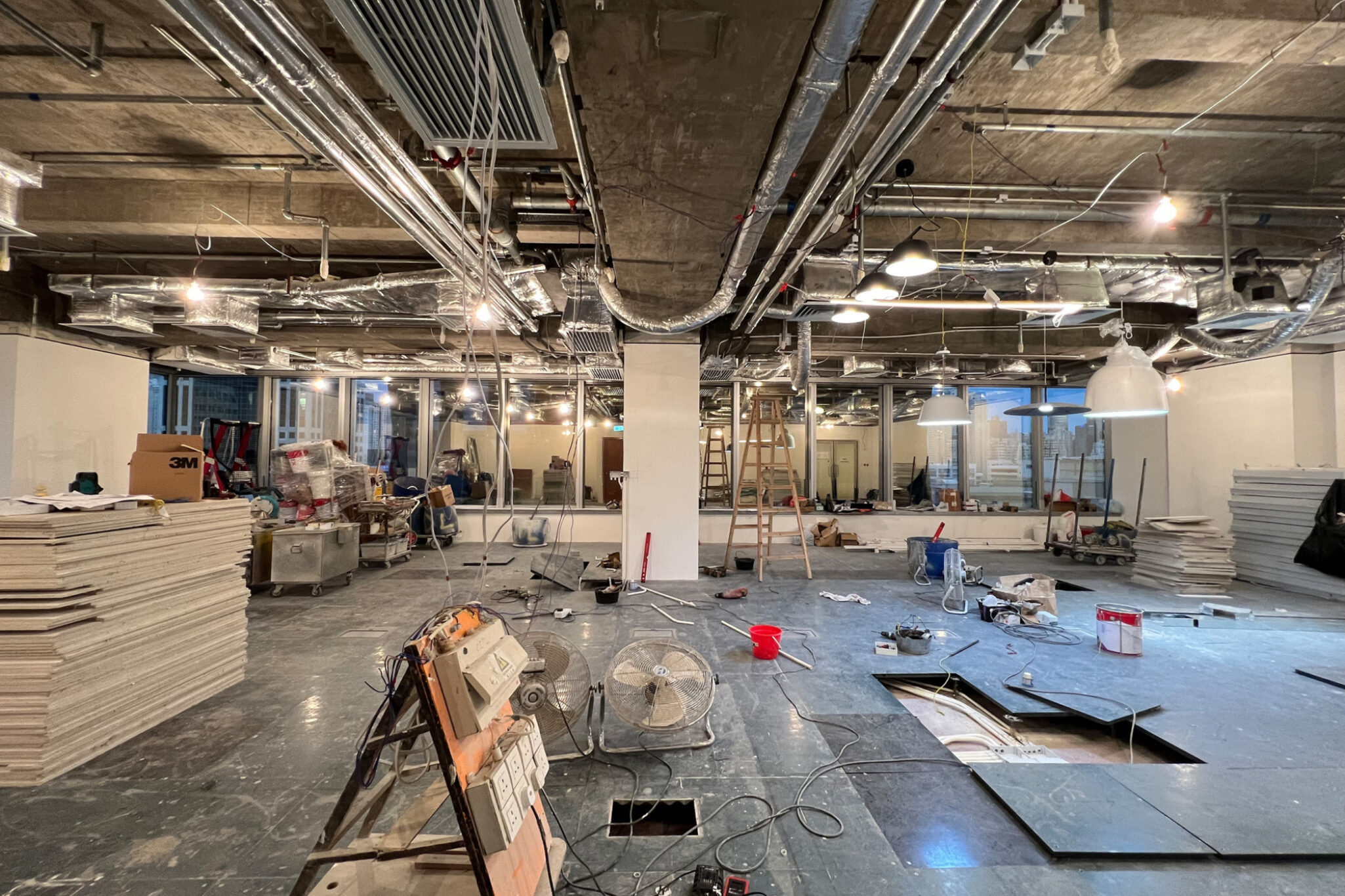 A wide-angle shot of an indoor office office workshop under maintenance work by Studio X
